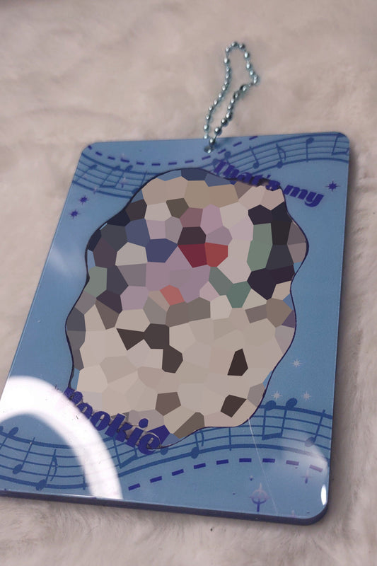 Colorful rock-shaped keychain with musical notes on a blue background